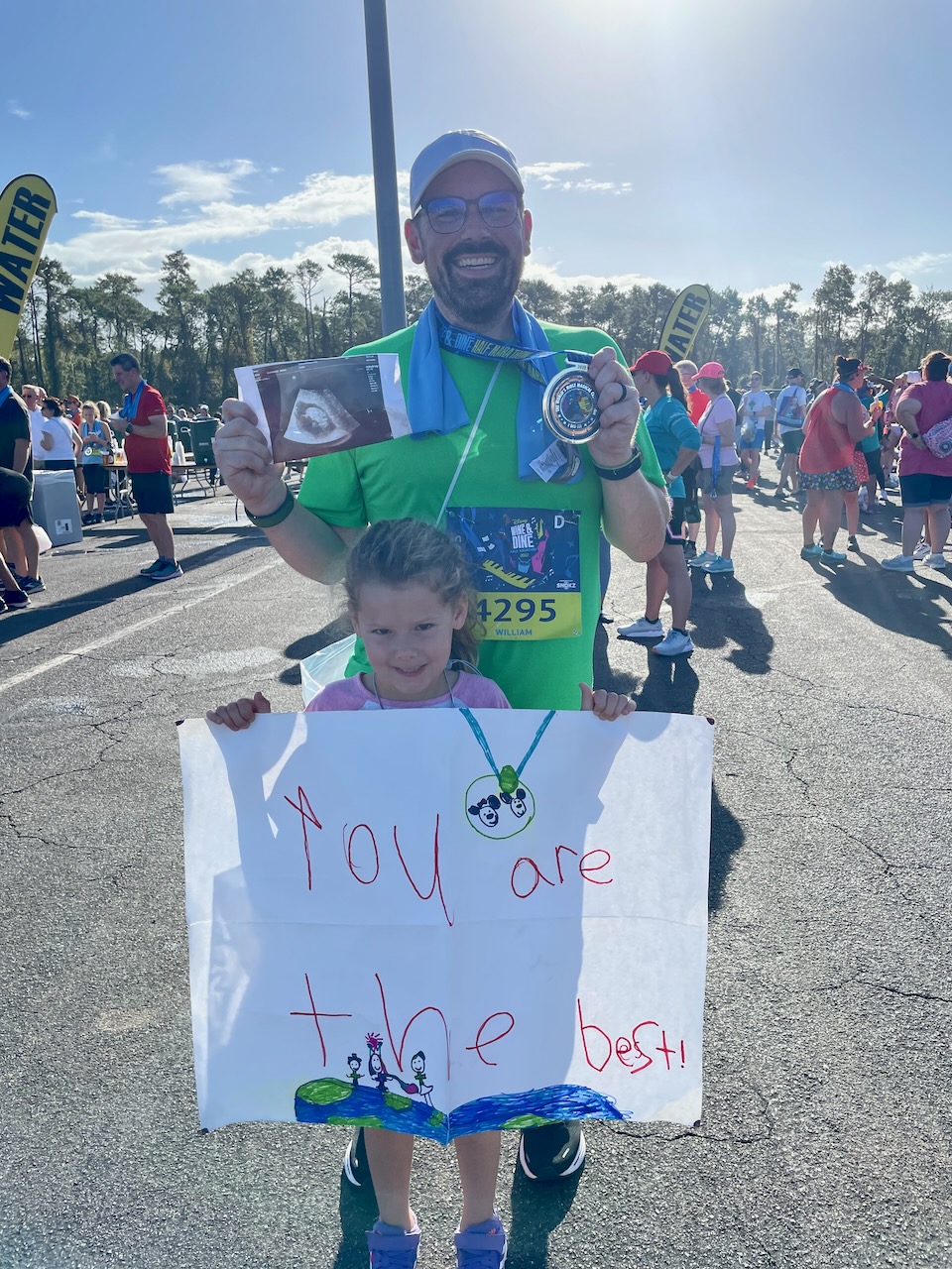 Will posing with his daughter, Etta, and an ultrasound picture of his younger daughter Bea after he finished the 2022 Disney Wine & Dine Half Marathon.